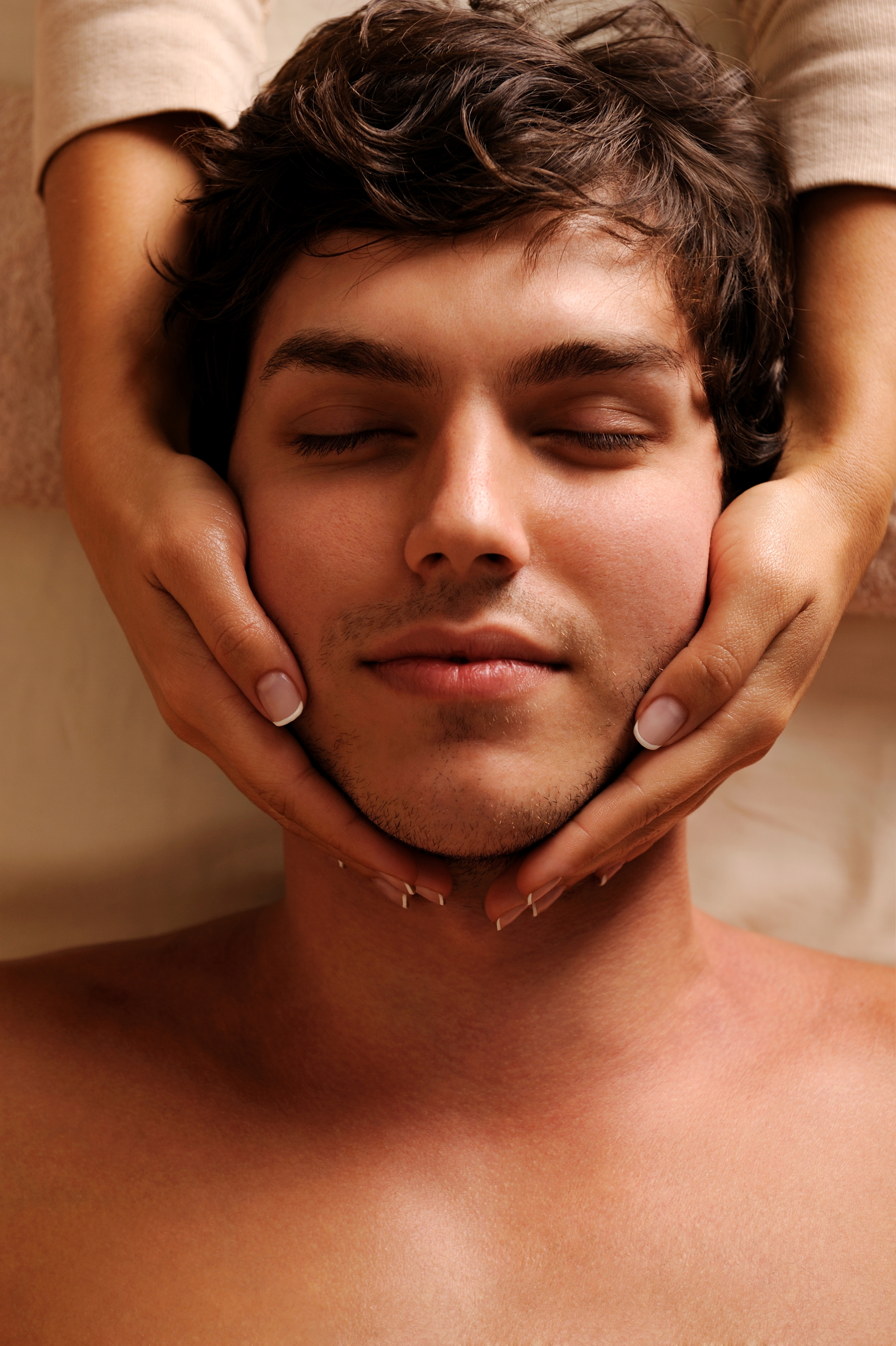 masseur-doing-massaging-temples-for-young-handsome-man-high-angle-view