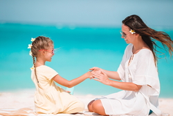 young-mother-applying-sun-cream-to-daughter-nose-on-the-beach-sun-protection