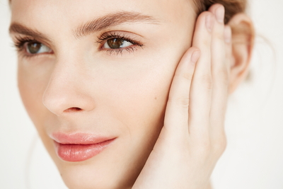 close-up-of-young-beautiful-girl-smiling-touching-face-spa-beauty-health-and-cosmetology-concept